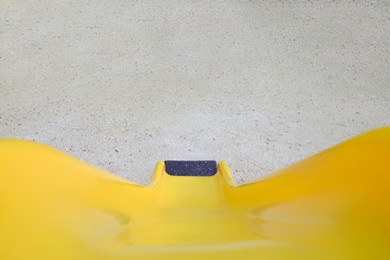 Photo of Empty playground with bright yellow slide and rest area outdoors