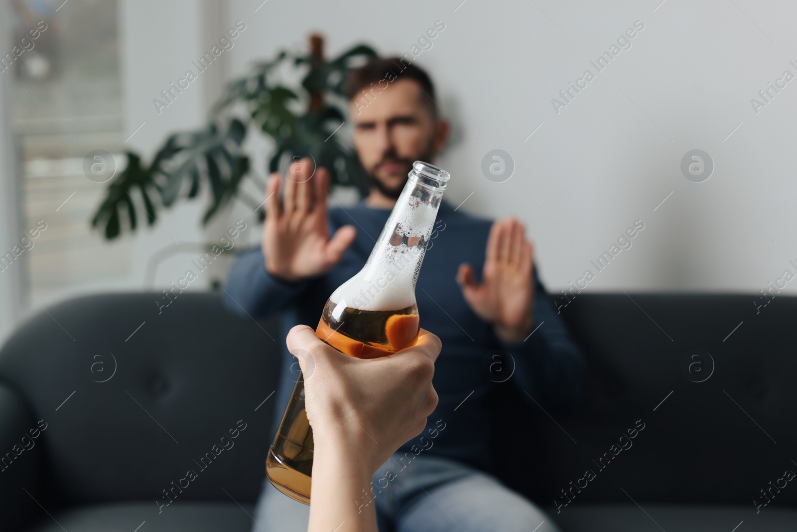 Photo of Man refusing to drink beer indoors, closeup. Alcohol addiction treatment