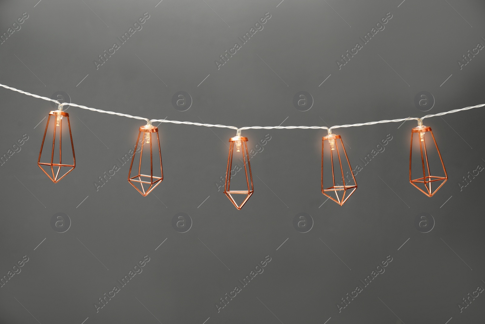 Photo of Garland of lamps with light bulbs on grey background