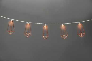 Photo of Garland of lamps with light bulbs on grey background