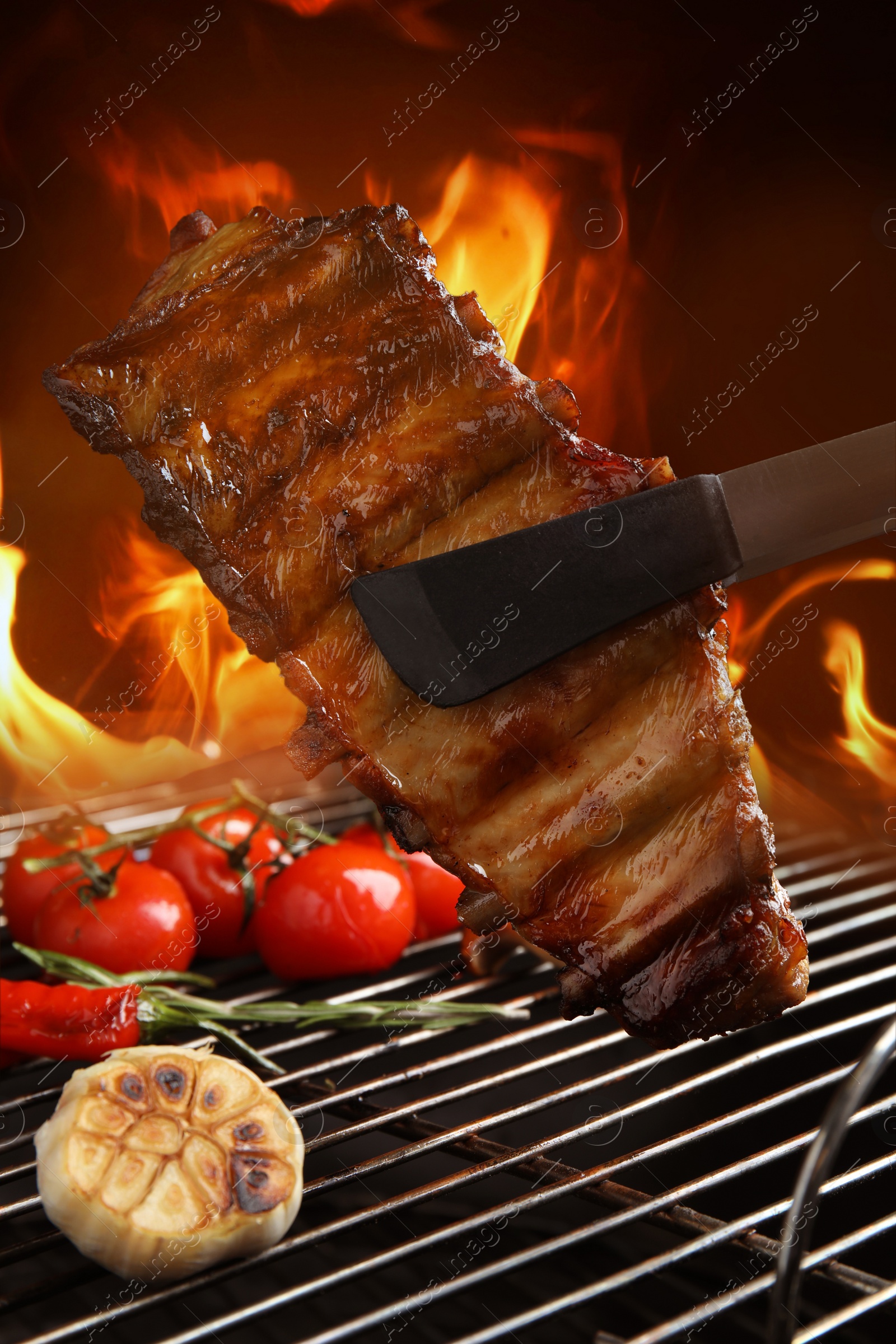 Image of Delicious ribs and vegetables on barbecue grill