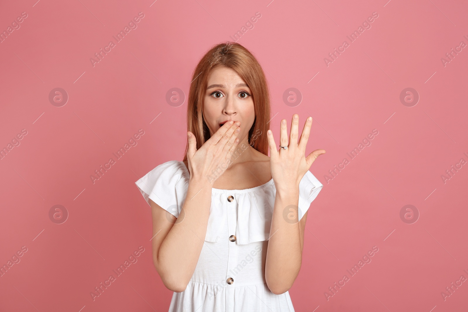 Photo of Excited woman with engagement ring on pink background
