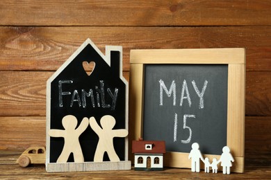 Chalkboards, family figures and toys on wooden background