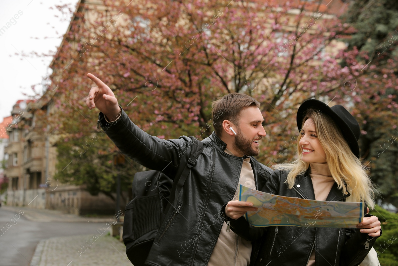 Photo of Couple of tourists with map planning trip on city street