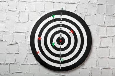 Arrows hitting dart board on white textured wall