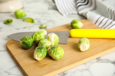 Photo of Fresh Brussels sprouts on white marble table, closeup