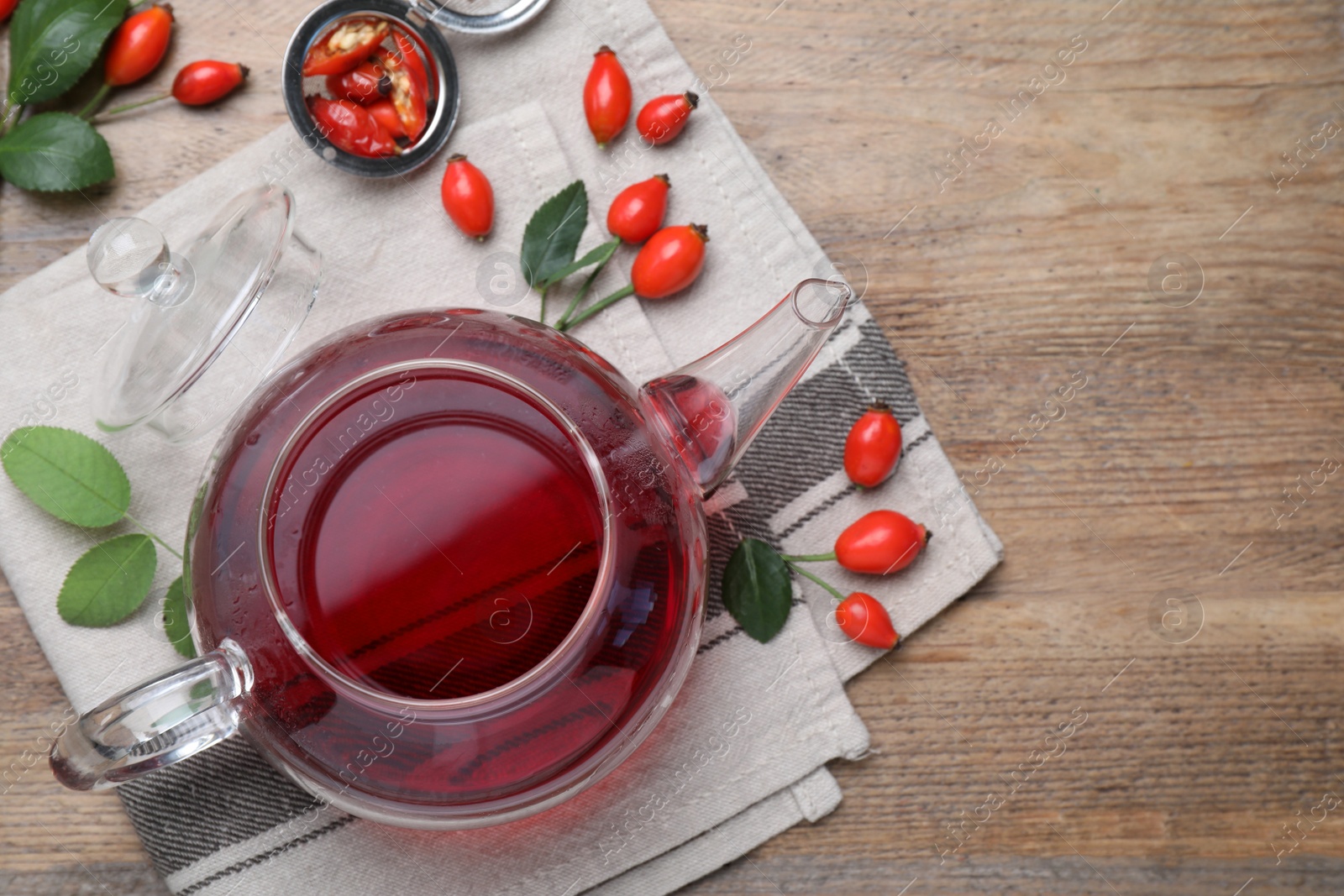 Photo of Flat lay composition with aromatic rose hip tea on wooden table. Space for text