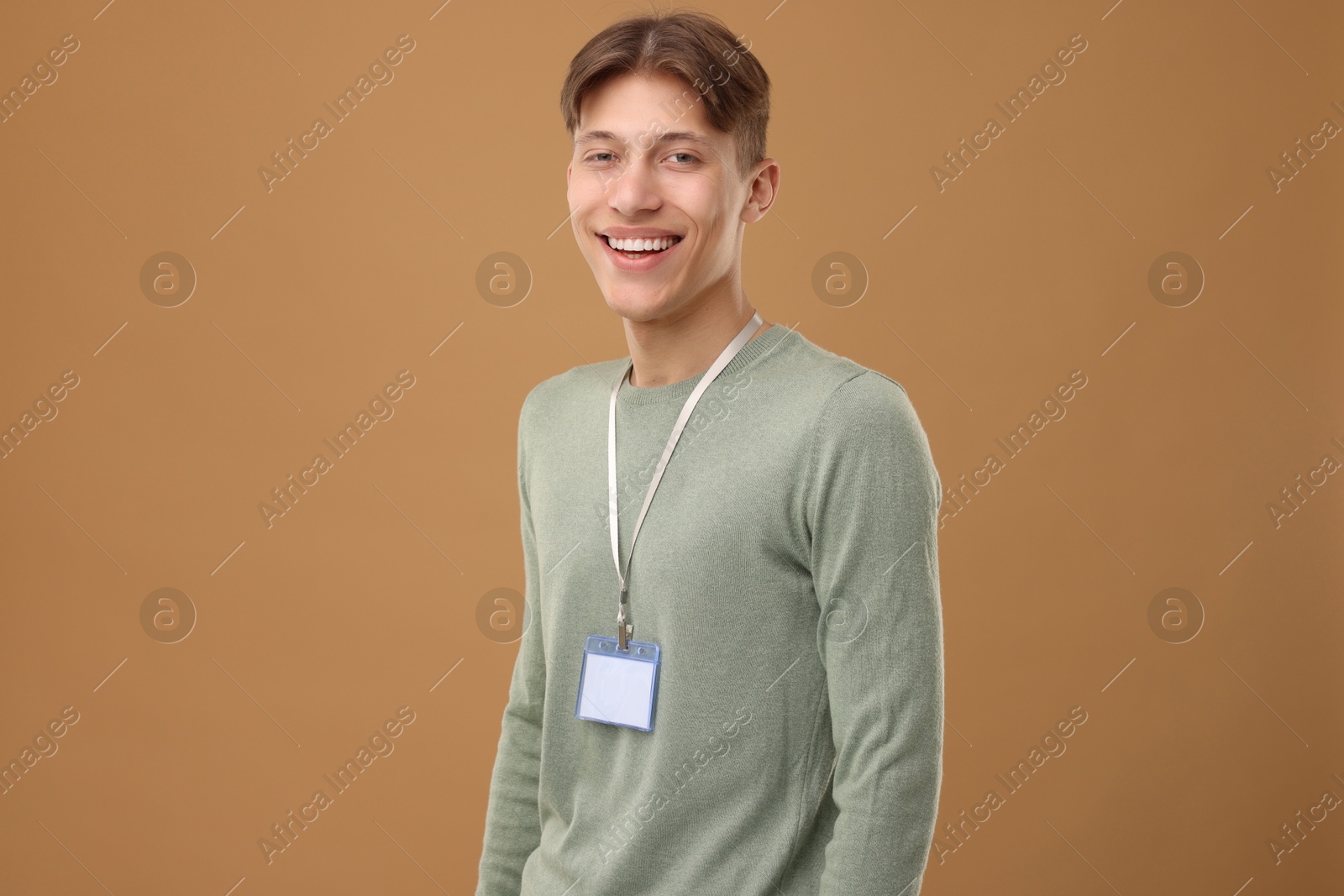 Photo of Happy man with blank badge on light brown background