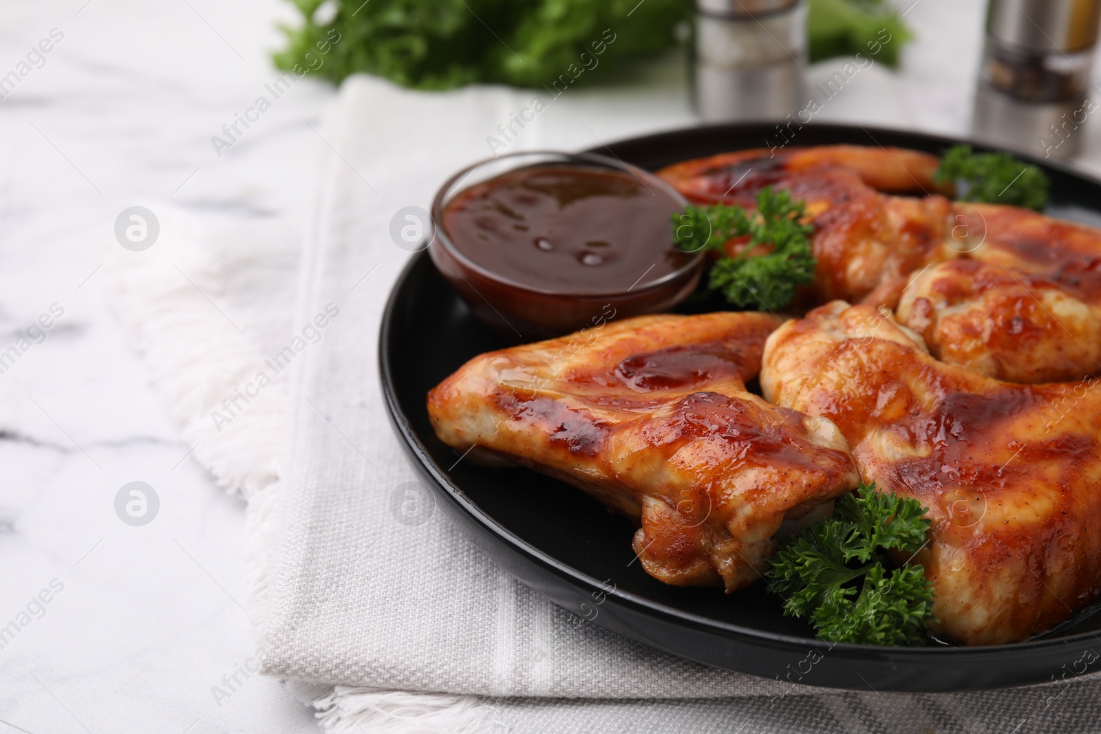 Photo of Fresh marinade and chicken wings on white table, closeup. Space for text