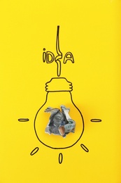 Composition with crumpled banknote, drawing of lamp bulb and word IDEA on color background. Creative concept