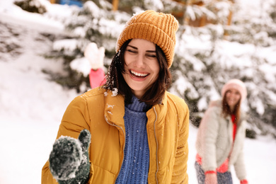 Group of friends playing snowballs outdoors. Winter vacation