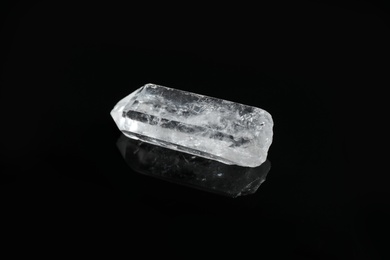Photo of Beautiful rock crystal gemstone on black background