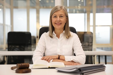 Photo of Portrait of confident lawyer working at table in office