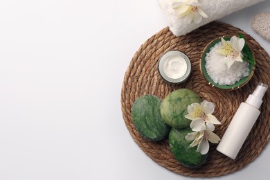 Flat lay composition with different spa products and beautiful flowers on white table. Space for text