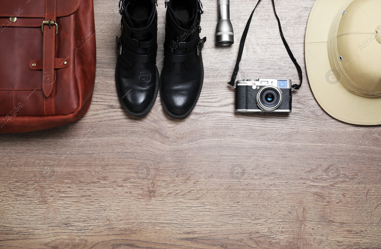 Photo of Flat lay composition with different safari accessories on wooden background, space for text