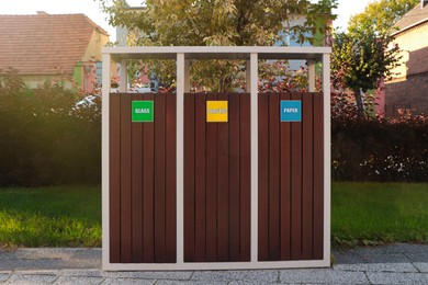 Photo of Different sorting bins for waste recycling on sunny day outdoors