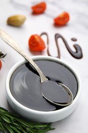 Photo of Organic balsamic vinegar and cooking ingredients on white marble table, closeup