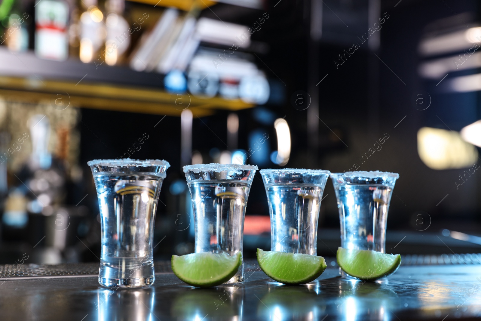 Photo of Mexican Tequila shots with lime slices on bar counter