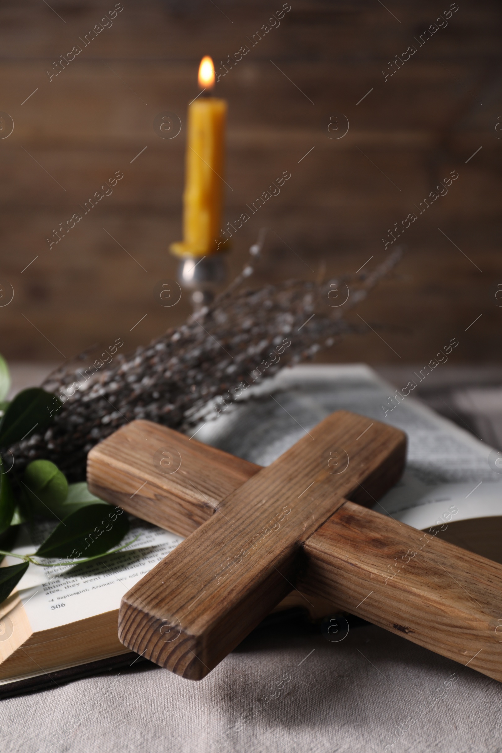 Photo of Cross, Bible and willow branches on table, closeup