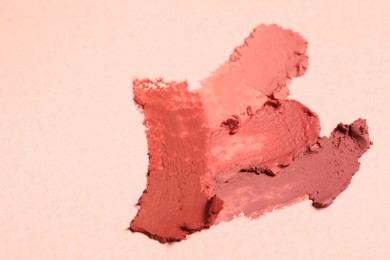 Photo of Smears of beautiful lipsticks on light background. Space for text