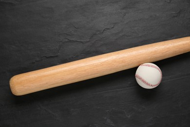 Photo of Baseball bat and ball on black background, top view. Sports equipment