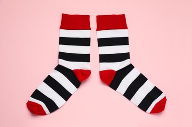 Photo of Striped socks on pink background, flat lay