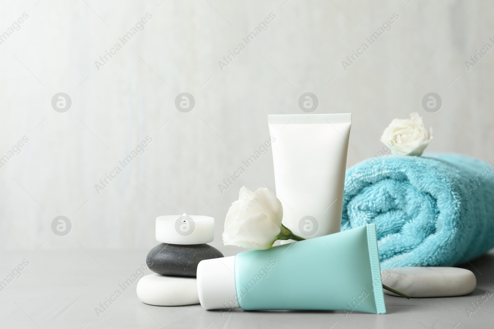 Photo of Composition with cosmetic products on light grey stone table. Space for text