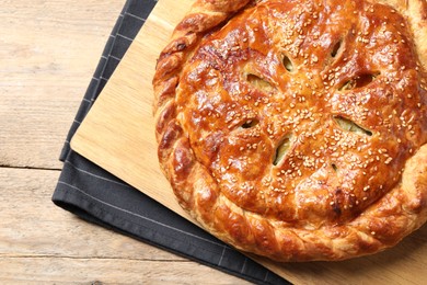 Photo of Tasty homemade pie with filling on wooden table, top view