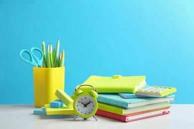 Photo of Different school stationery on white table against light blue background