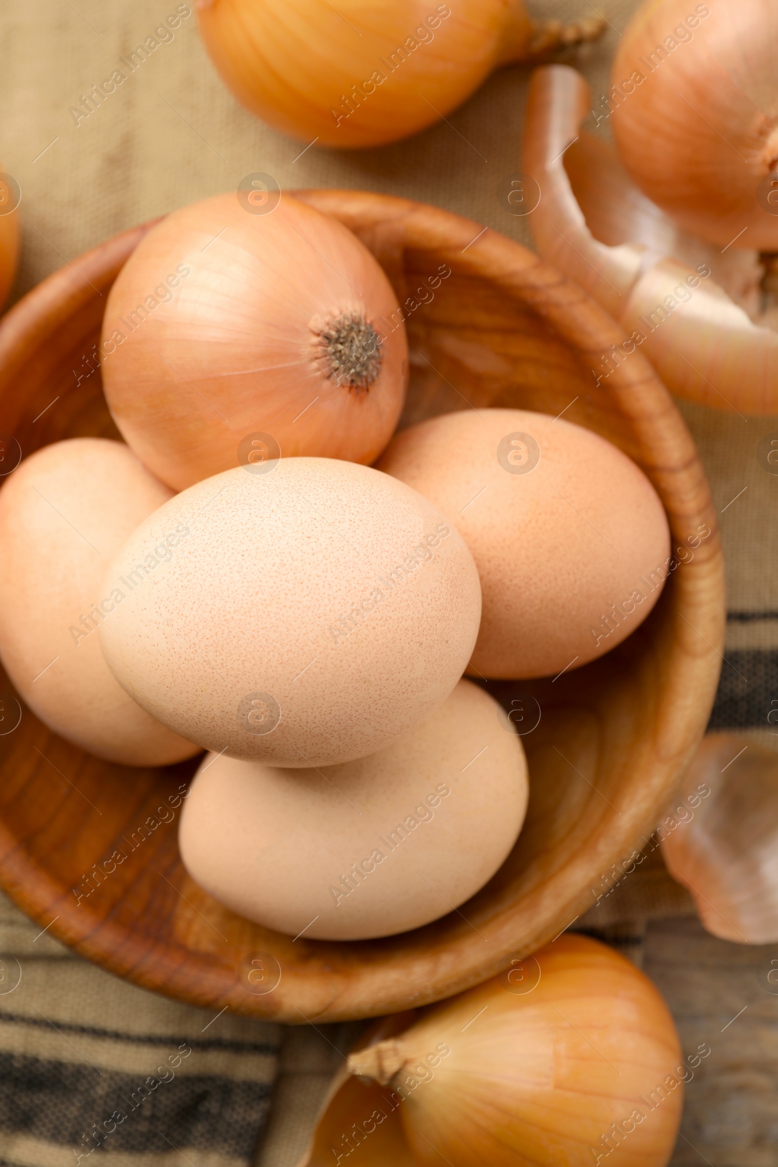 Photo of Easter eggs painted with natural dye and onions on table, flat lay