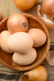 Easter eggs painted with natural dye and onions on table, flat lay