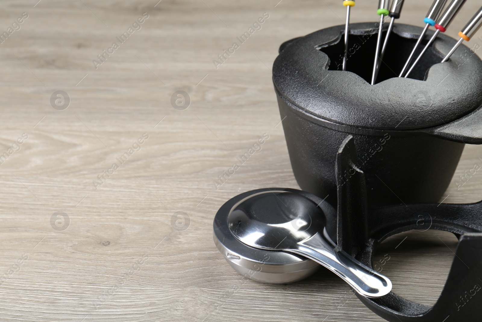 Photo of Fondue set on wooden table, space for text