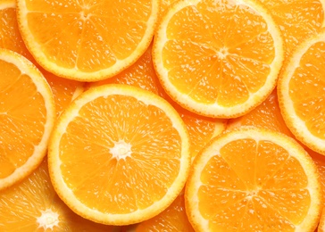 Photo of Juicy orange slices as background, top view. Citrus fruit