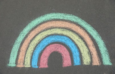 Photo of Child's chalk drawing of rainbow on asphalt, top view