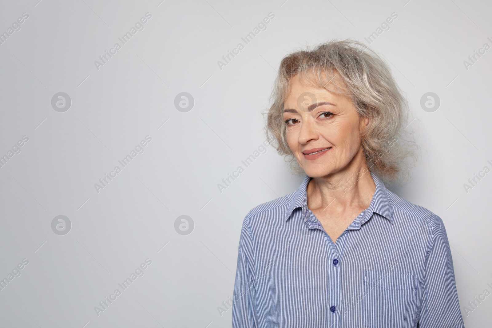 Photo of Portrait of mature woman on grey background. Space for text