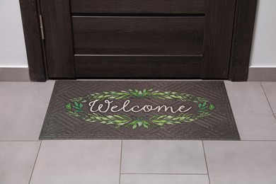 Photo of Beautiful doormat with word Welcome on floor near entrance