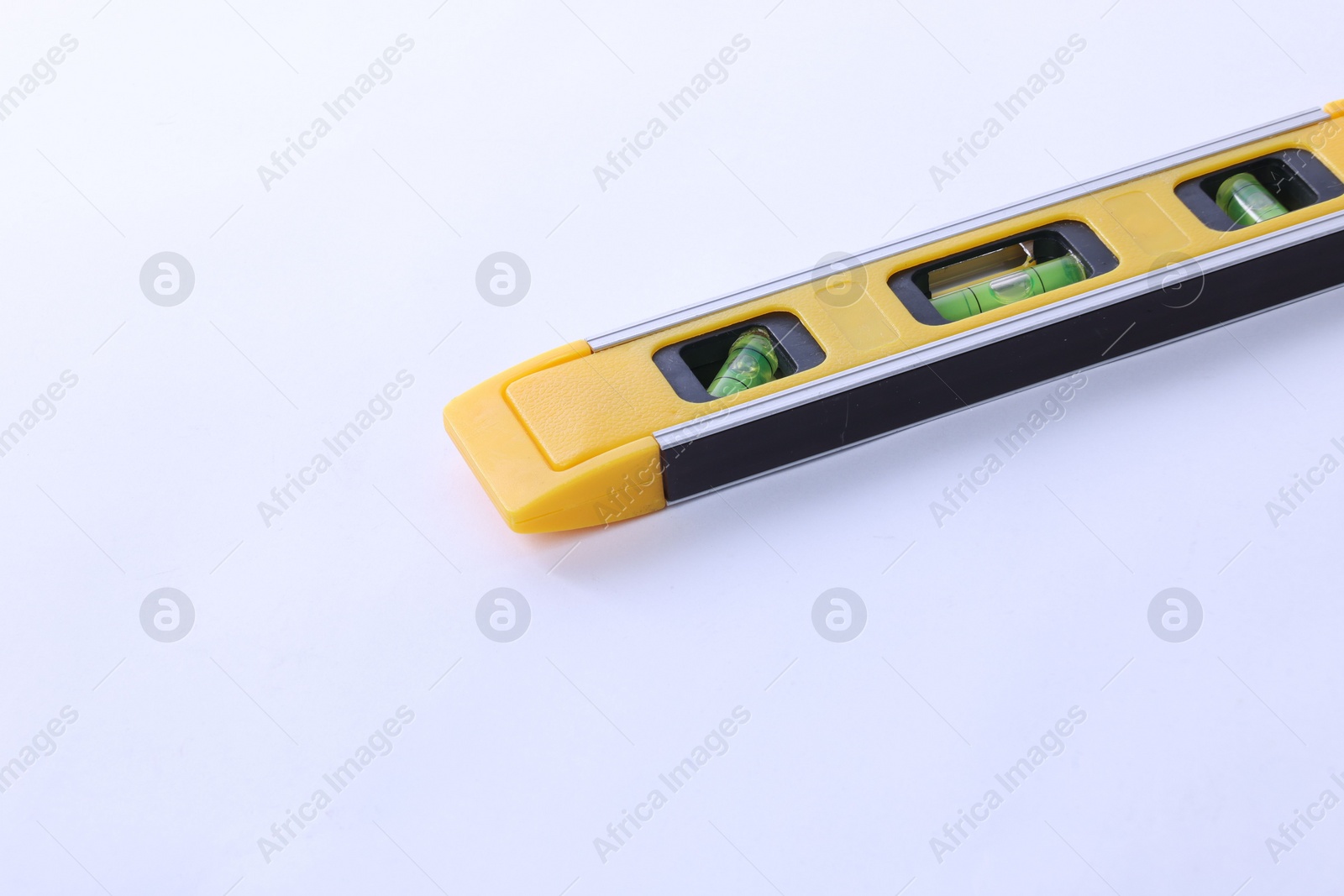 Photo of Yellow building level on white background. Construction tool