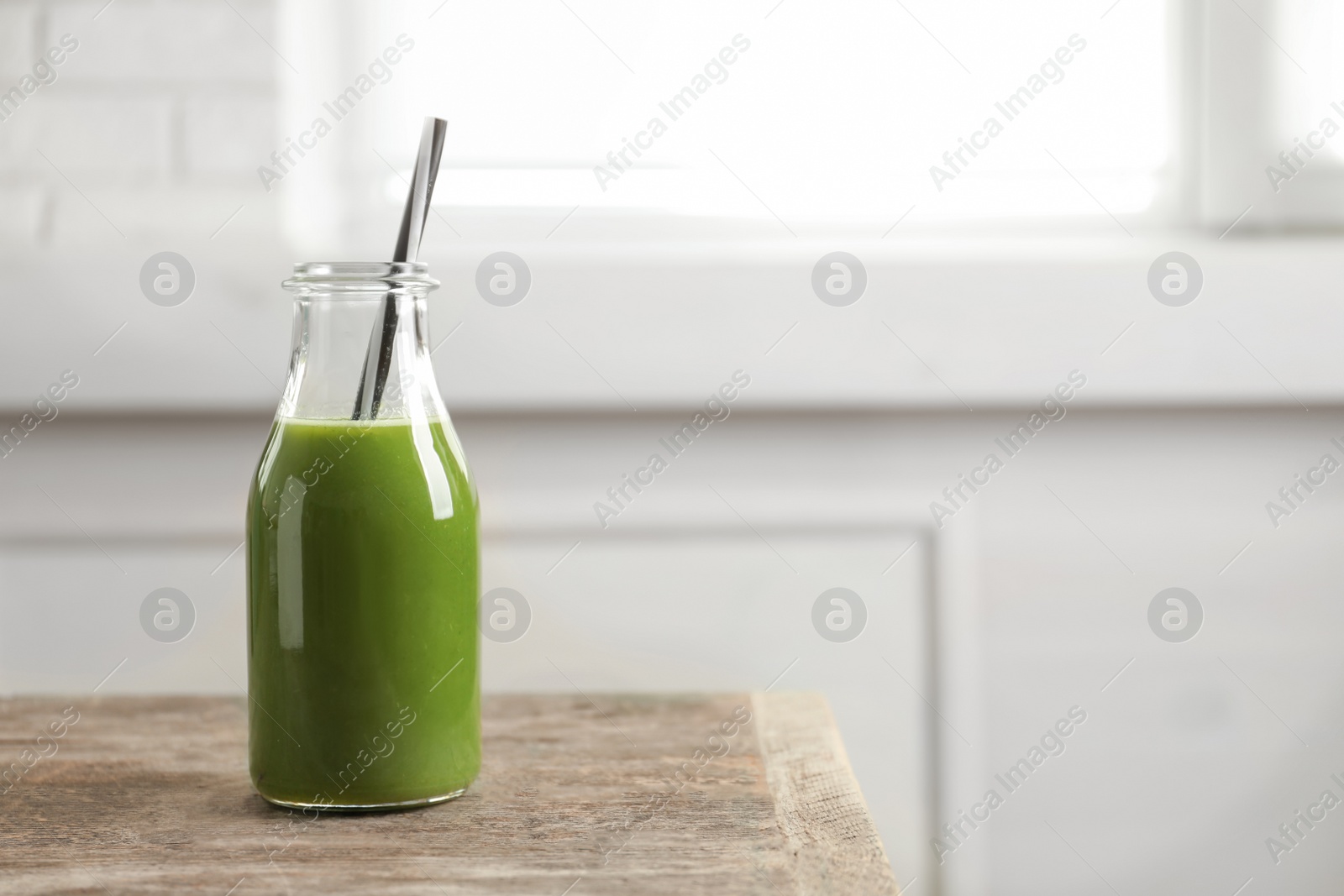 Photo of Bottle with delicious detox juice on wooden table