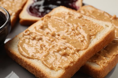 Photo of Delicious toasts with peanut butter on plate, closeup