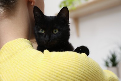 Photo of Owner with her adorable black cat at home, closeup