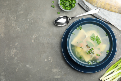 Photo of Delicious fish soup served on grey table, flat lay. Space for text