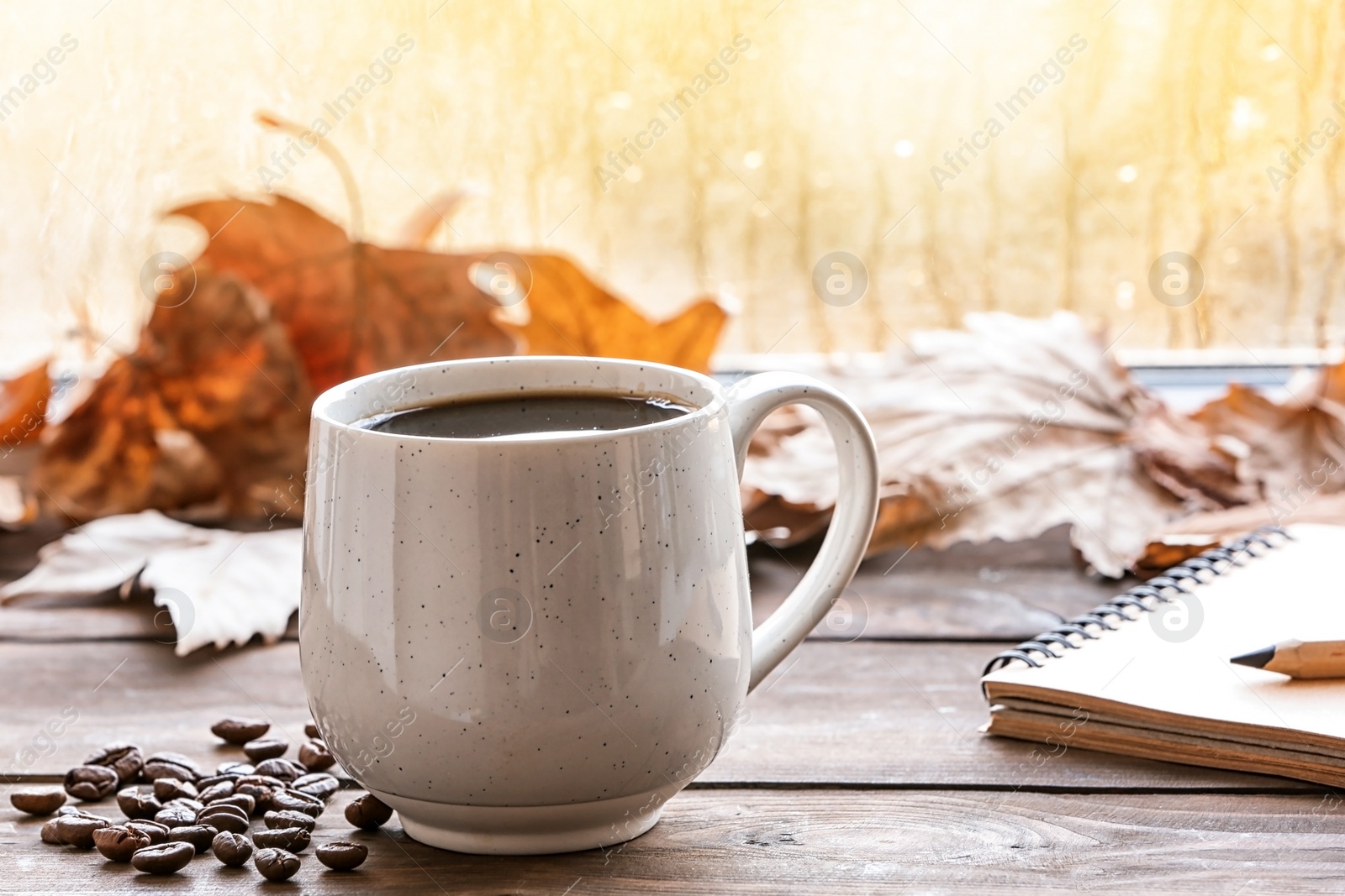 Photo of Composition with cup of hot cozy drink and autumn leaves on windowsill. Space for text