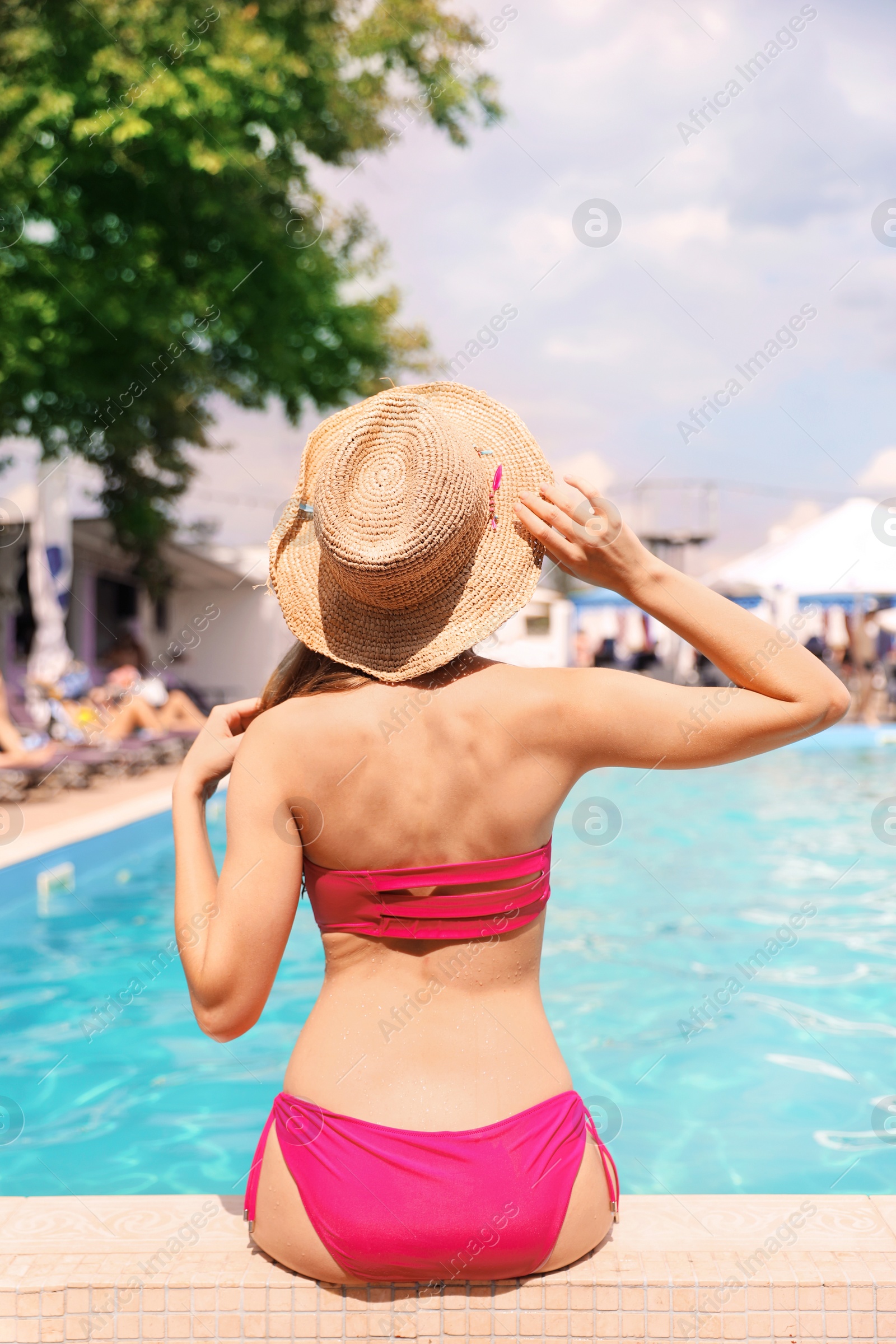 Photo of Young woman near pool on sunny day