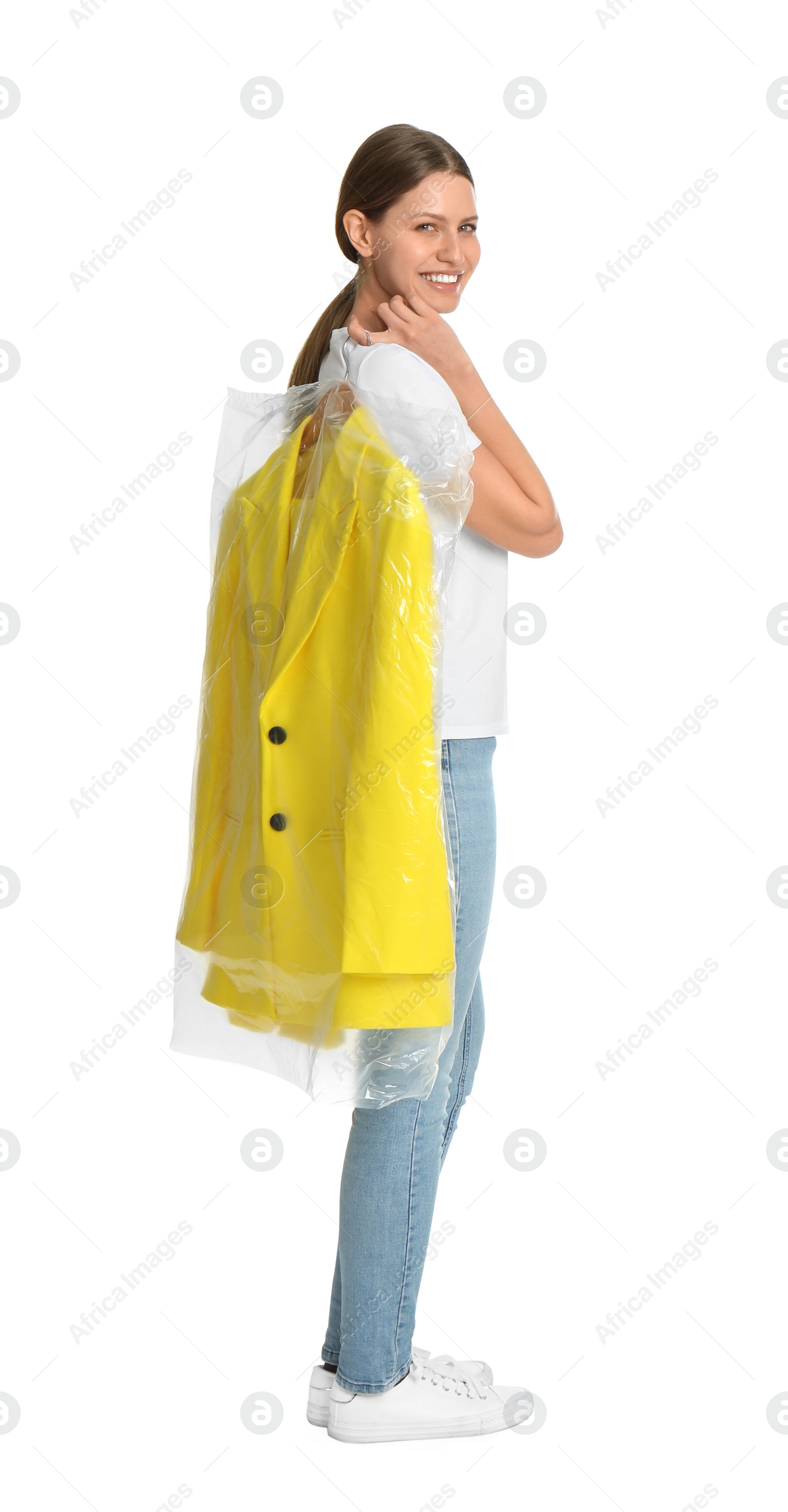 Photo of Young woman holding hanger with jacket in plastic bag on white background. Dry-cleaning service