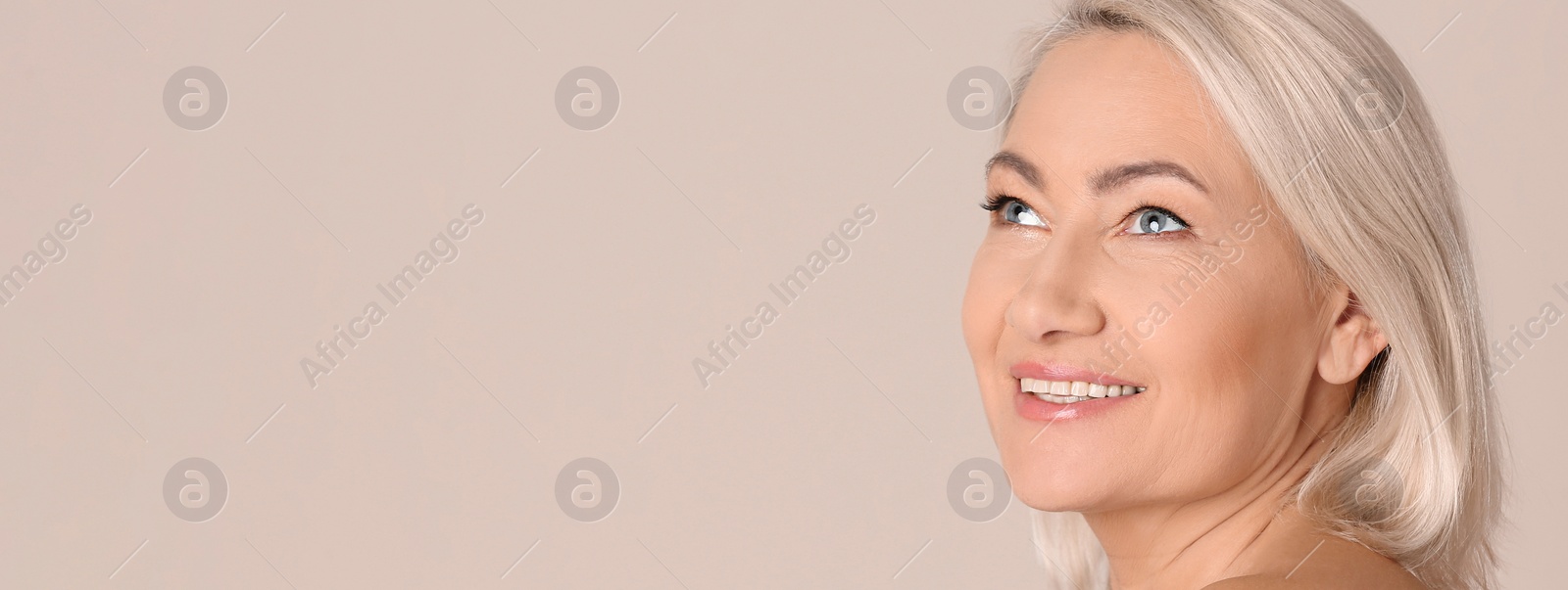 Image of Portrait of beautiful mature woman on beige background, space for text. Banner design