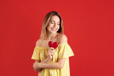 Portrait of woman with decorative heart on color background