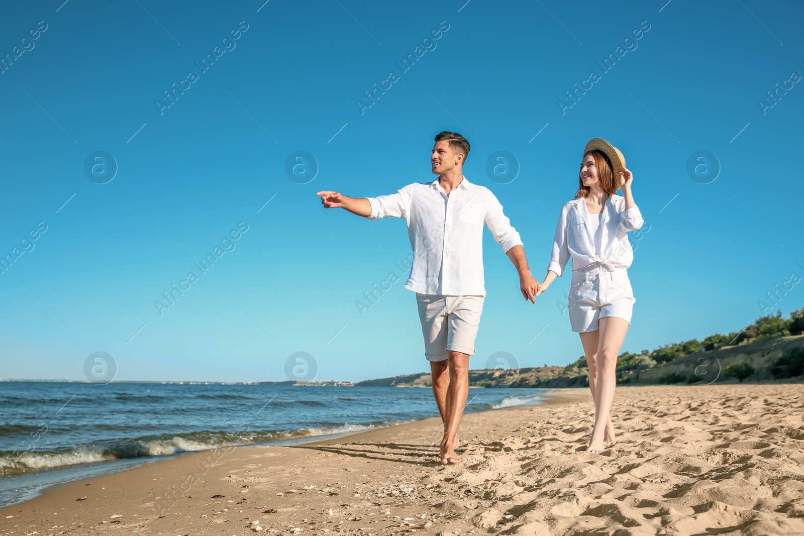 Photo of Lovely couple walking on beach. Space for text