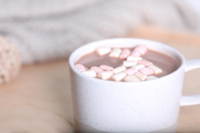 Photo of Cup of aromatic cacao with marshmallows on blurred background, closeup. Space for text