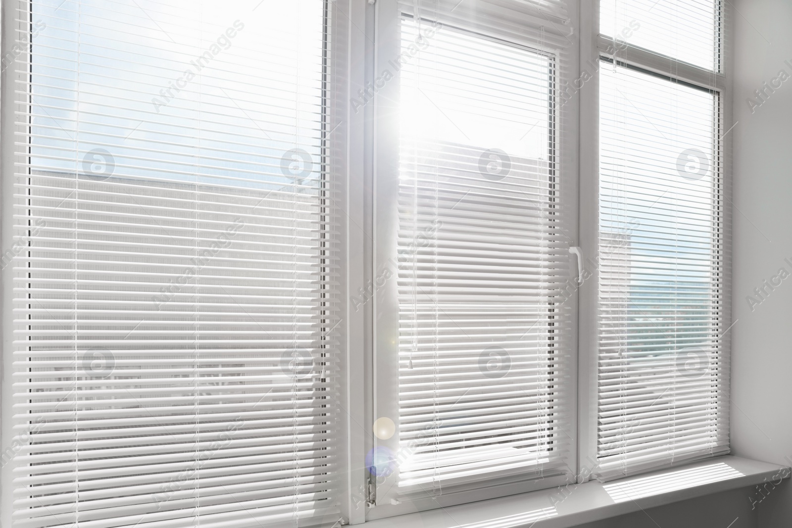 Photo of Stylish window with horizontal blinds in room