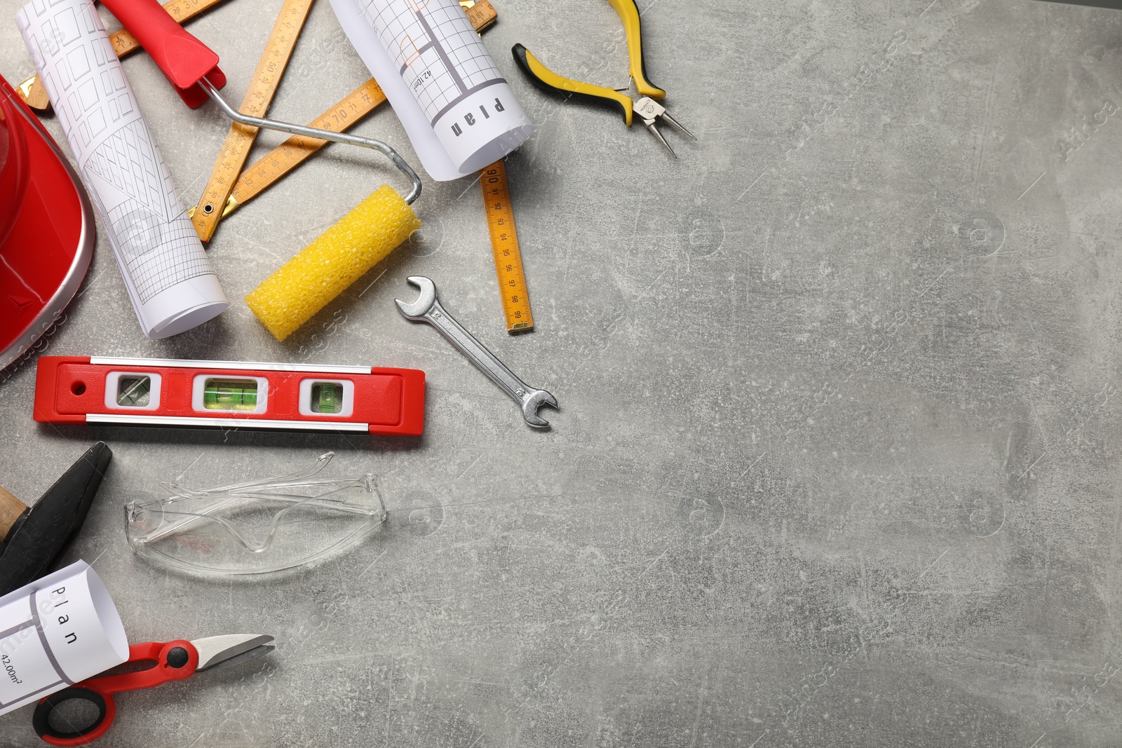 Photo of Flat lay composition with building level and other construction tools on grey table, space for text